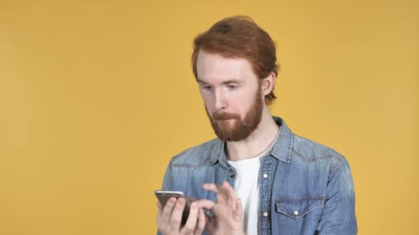 Redhead Man Browsing Smartphone Isolato Sfondo Giallo — Video Stock