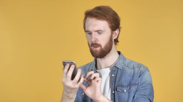 Ruiva Homem Animado Para Sucesso Usar Smartphone Isolado Fundo Amarelo — Vídeo de Stock