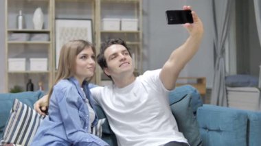 Genç çift alarak Selfie kanepede otururken Smartphone ile