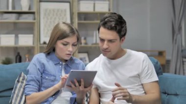 Üzgün genç çift tepki kullanarak Tablet ise mali kaybı