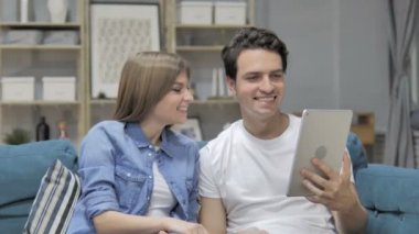 Tablet genç çift kanepede oturan tarafından online görüntülü sohbet