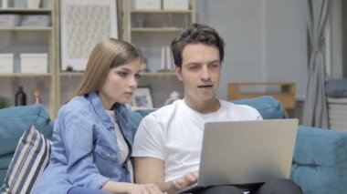 Heyecanlı genç çift kutluyor başarı kullanarak Laptop süre