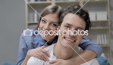 Kameraya bakarak aşık gülümseyen romantik genç çift