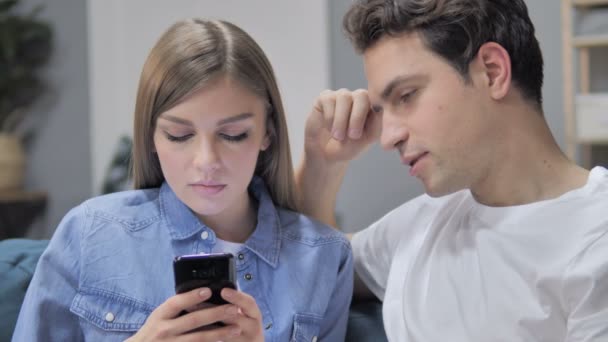 使用智能手机与令人困惑的在线产品的谈话年轻夫妇 — 图库视频影像