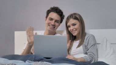 Laptop yatakta mutlu genç çift tarafından online görüntülü sohbet