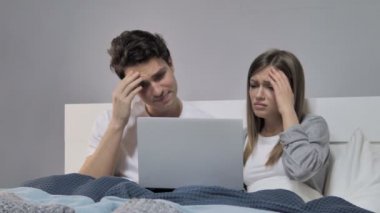 Young Couple in Bed Reacting to Failure