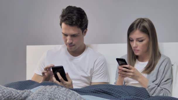 Jeune Couple Utilisant Téléphone Intelligent Tout Relaxant Lit — Video