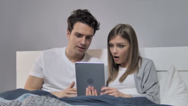 Junges Paar Bejubelt Sieg Mit Tablet Bett — Stockvideo