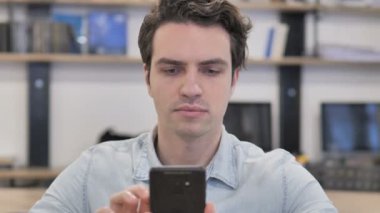 Portrait of Creative Man in Shock while Using Smartphone