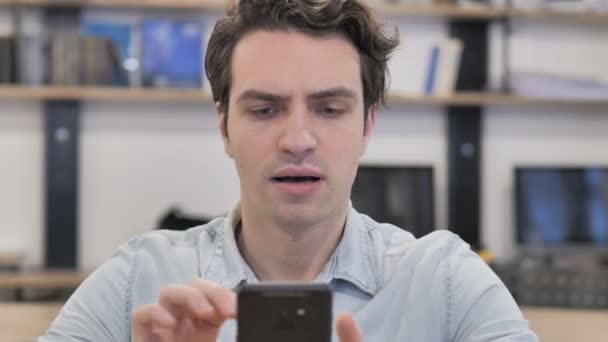 Retrato Del Hombre Creativo Reaccionando Pérdida Mientras Usa Teléfono Inteligente — Vídeos de Stock