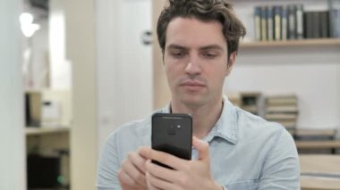 İş için telefon ve dizüstü bilgisayar kullanan yaratıcı adam