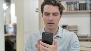 Yaratıcı adam heyecanlı Smartphone kullanarak süre başarı için