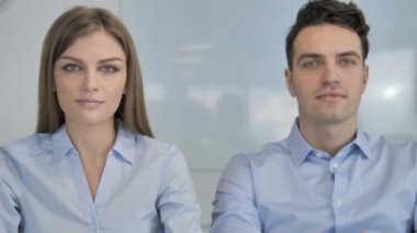 Office, kamerada bakarak gülümseyen genç iş adamları iş arkadaşları