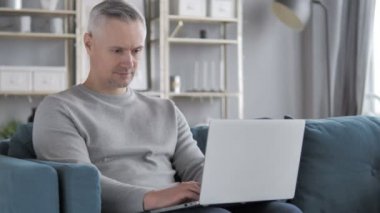 Kucağına içinde Laptop üzerinde gri saçlı adam