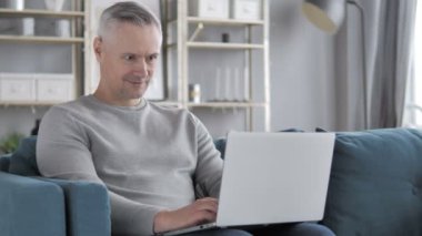 Online Video sohbet etmek üstünde Laptop sıradan gri saçlı adam tarafından