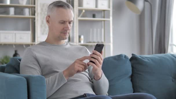 灰色的头发人浏览智能手机 使用互联网 — 图库视频影像