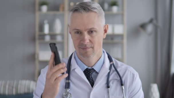 Ανώτερος Γιατρός Συζητώντας Ασθενή Κατά Διάρκεια Ομιλίας Του Τηλεφώνου — Αρχείο Βίντεο