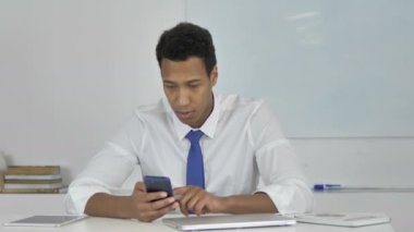 Afro-Amerikan işadamı üzgün Smartphone kullanarak süre kaybı için