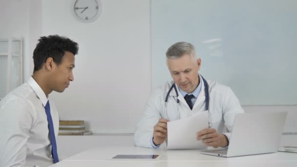 Médico Sénior Conversando Com Paciente Clínica Discutindo Relatório Médico — Vídeo de Stock