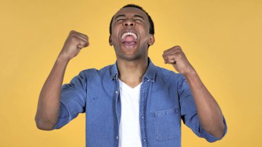 Afrika delikanlı başarı üzerinde sarı arka plan izole kutlama