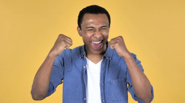 Afrika delikanlı başarı üzerinde sarı arka plan izole kutlama