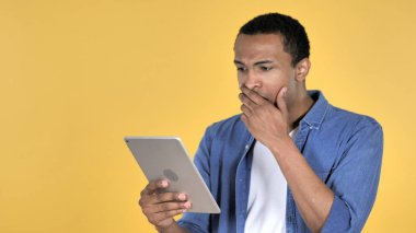 Süre kullanarak Tablet izole mavi zemin üzerine şok hayal kırıklığına uğramış Afrika adam