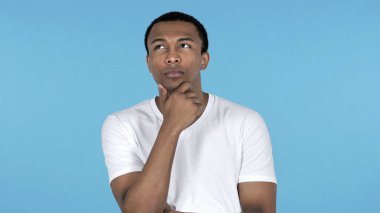 Üzerinde mavi arka plan izole dalgın Afrika delikanlı düşünme