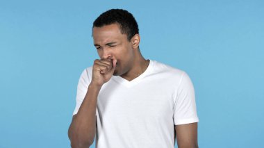 Hasta genç Afrika adam üzerinde izole mavi arka plan öksürük