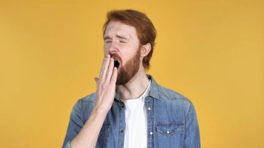 Kızıl saçlı adam sarı zemin üzerine esneme