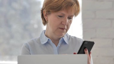 Eski işyerinde Smartphone kullanan kadın