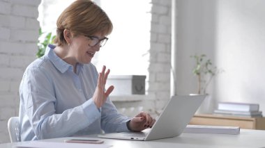 Online Video sohbet etmek üstünde Laptop kadın tarafından işyerinde