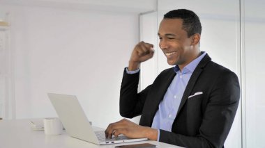 Afrika işadamı dizüstü bilgisayarda çalışma, başarı kutluyor