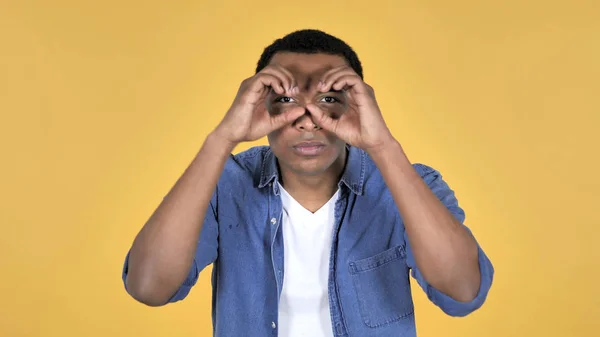 Молодий Африканський Чоловік Шукає Бінокль Ручної Роботи Ізольовані Жовтому Тлі — стокове фото