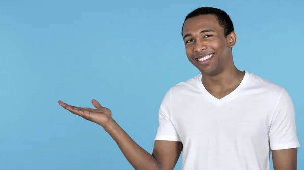 Africano Homem Mostrando Produto Lado Fundo Azul — Fotografia de Stock