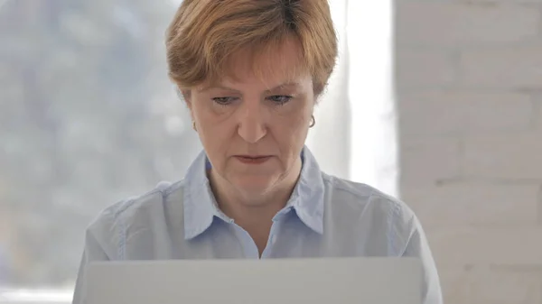 Old Woman Working On Laptop in Office