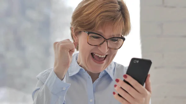 Old Woman Excited for Success while Using Smartphone