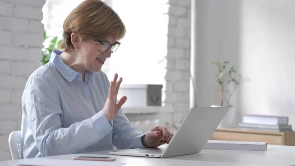 在线视频聊天的笔记本电脑在工作中的妇女 — 图库照片