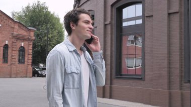 Telefonda tartışırken yürüyen adam