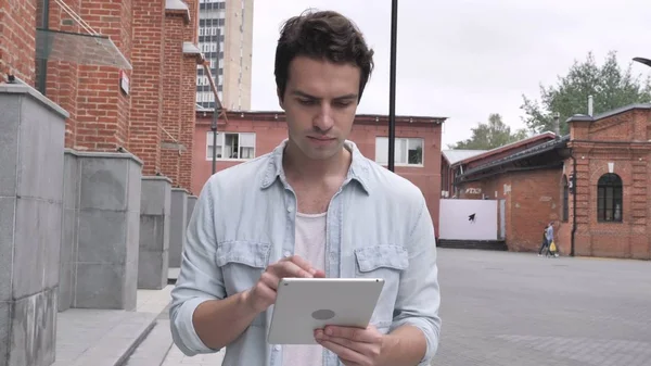Walking Man Using Tablet for Internet