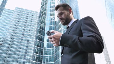 İşadamı İşletme Binası yakınındaki Smartphone kullanarak meşgul