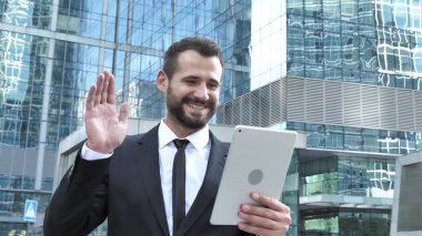 İş adamı sokakta yürürken tarafından tablet online görüntülü sohbet