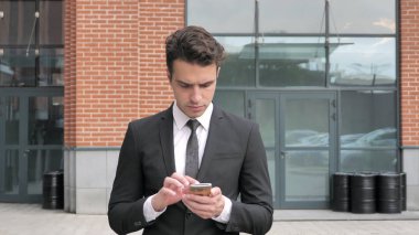 İşadamı Smartphone kullanarak yürüyüş