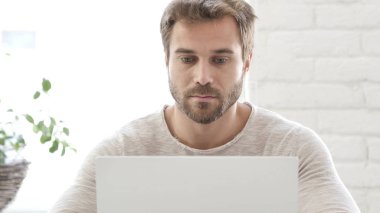 Meşgul bir adam iş dizüstü bilgisayarda yazarak