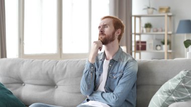 Dalgın adam yaratıcı uzayda kanepede otururken düşünüyorum