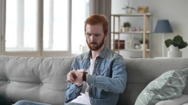 Kızıl saçlı adam Smartwatch kullanarak 
