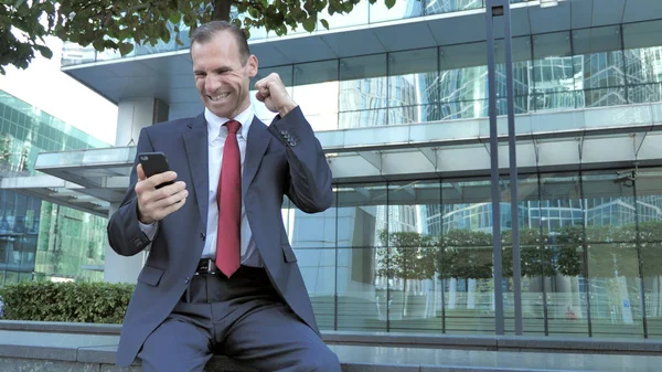Middle Aged Man Excited for Success while Using Smartphone
