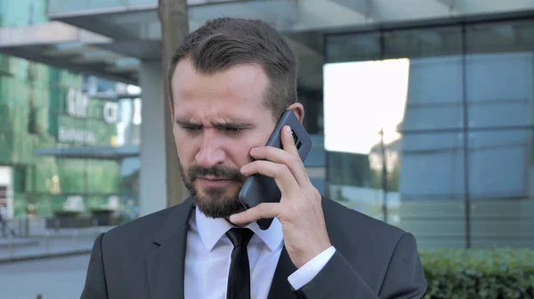 Angry Businessman Talking on Phone
