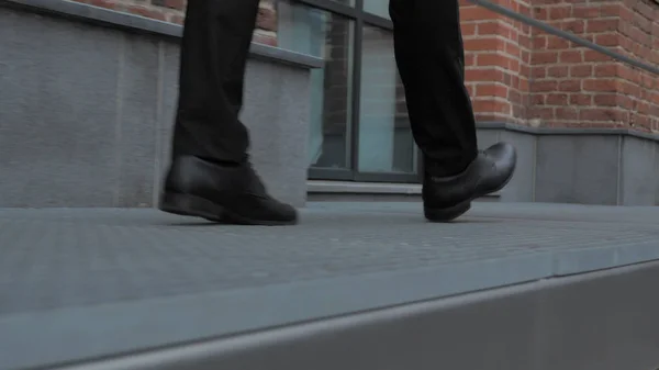 Close Up of Walking Feet Near Office Building