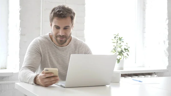 Lettura Casuale Ridente Del Progettista Sullo Smartphone Sul Lavoro — Foto Stock