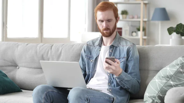 Beard Man Using Laptop and Smartphone at Creative Office